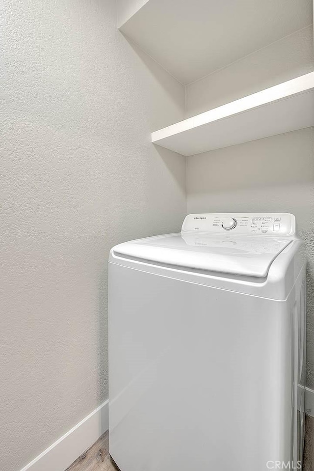 laundry room with washer / dryer and light wood-type flooring