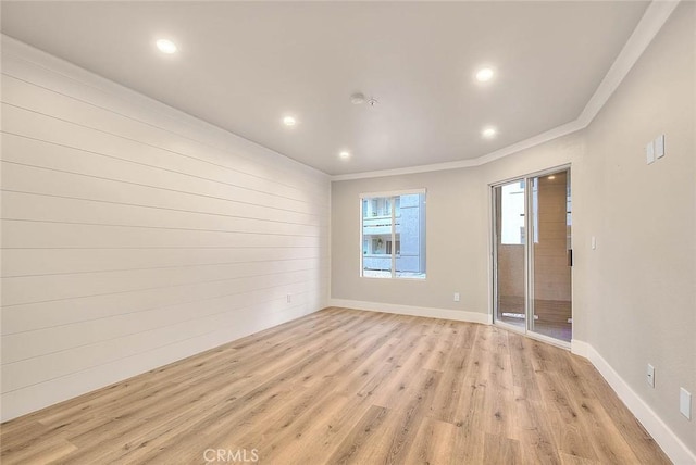 empty room with ornamental molding and light wood-type flooring