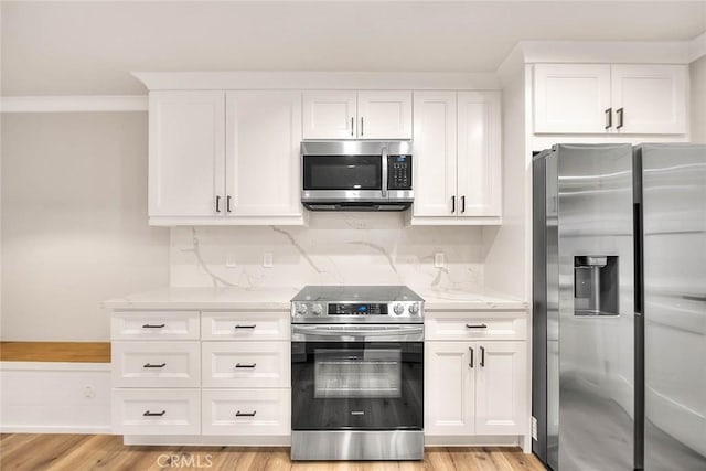 kitchen with light stone counters, stainless steel appliances, light wood-type flooring, and white cabinets