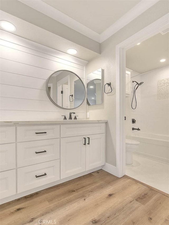 bathroom with crown molding, hardwood / wood-style floors, vanity, and toilet