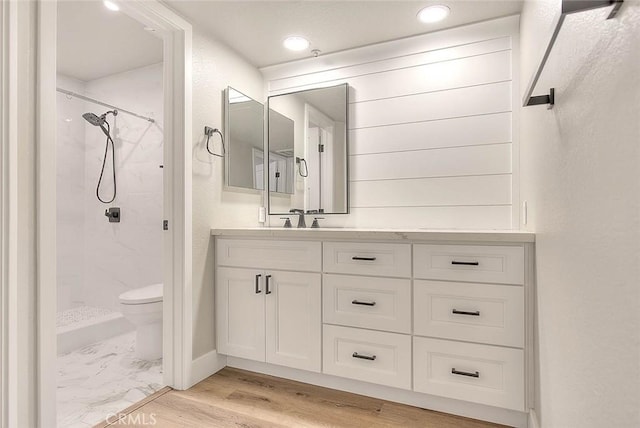 bathroom with walk in shower, vanity, toilet, and hardwood / wood-style floors