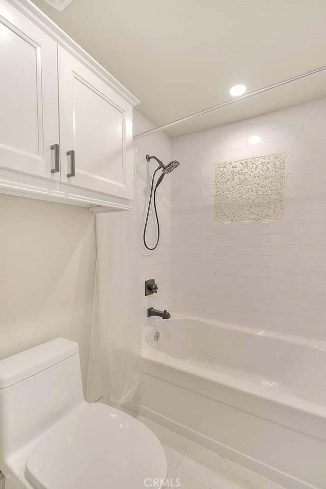 bathroom featuring tile patterned flooring, toilet, and shower / bath combo with shower curtain