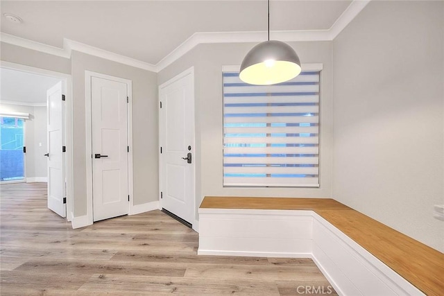 entrance foyer with ornamental molding and light hardwood / wood-style flooring