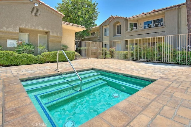 view of pool featuring a hot tub and a patio