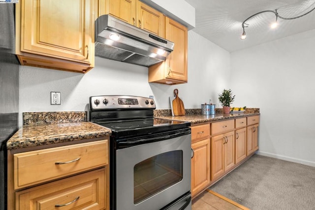 kitchen with dark stone countertops, light colored carpet, track lighting, and stainless steel range with electric cooktop