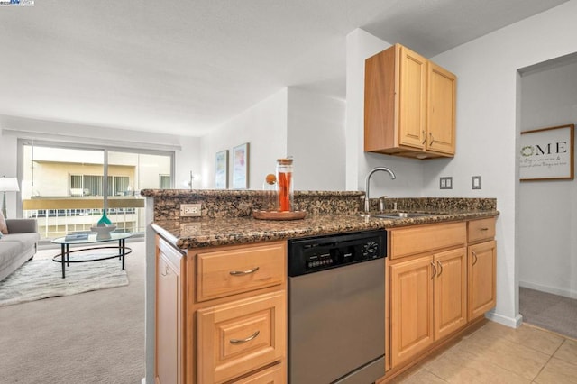 kitchen with sink, dark stone countertops, light carpet, stainless steel dishwasher, and kitchen peninsula