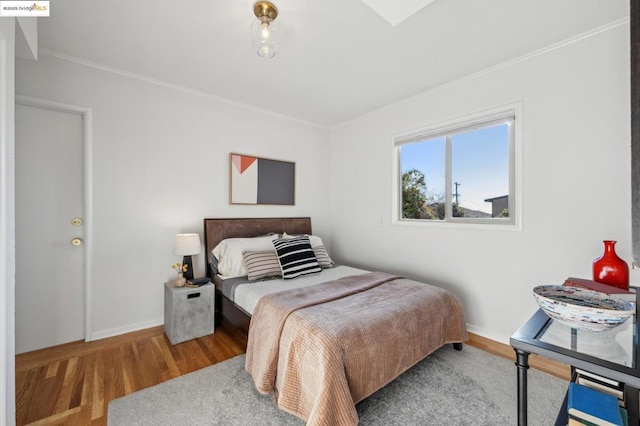 bedroom with ornamental molding and hardwood / wood-style floors