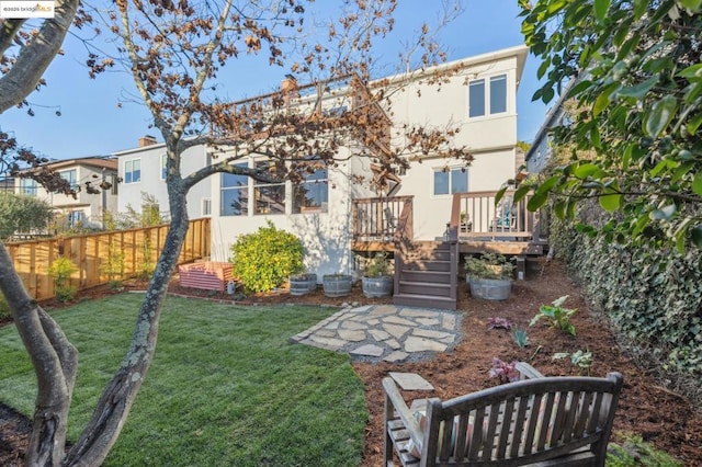 rear view of property featuring a wooden deck and a yard