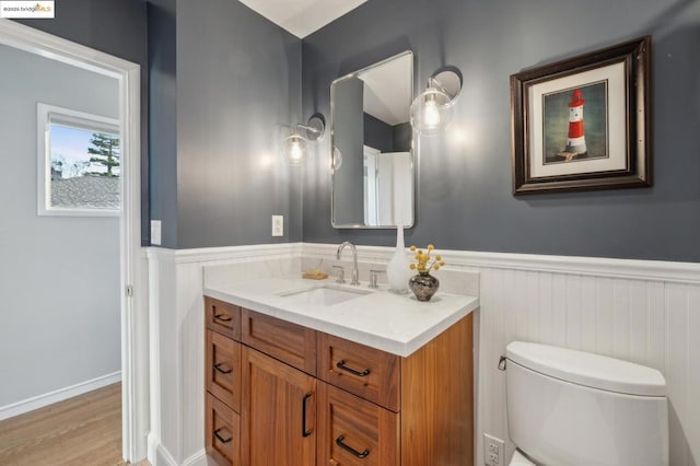 bathroom featuring hardwood / wood-style flooring, vanity, and toilet