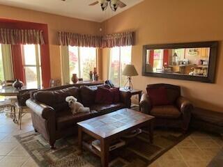 living room with ceiling fan and tile patterned flooring