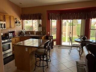 kitchen featuring sink, a breakfast bar area, backsplash, a center island, and stainless steel appliances