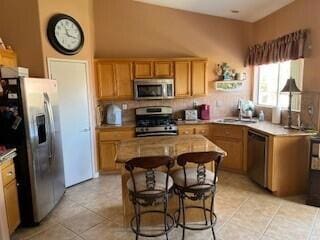 kitchen with light tile patterned floors, stainless steel appliances, and a kitchen island