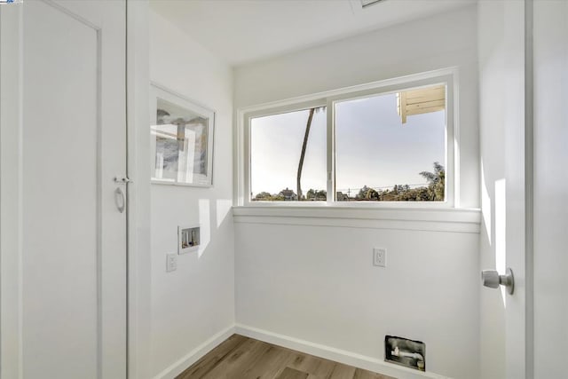 laundry room with hookup for an electric dryer, hookup for a washing machine, and light wood-type flooring