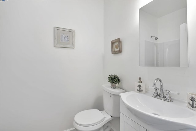 bathroom featuring vanity, toilet, and a shower