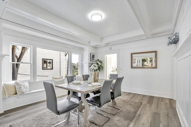 dining area featuring beamed ceiling and light hardwood / wood-style flooring