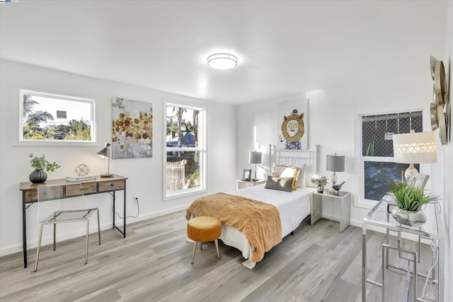 bedroom featuring multiple windows and light wood-type flooring