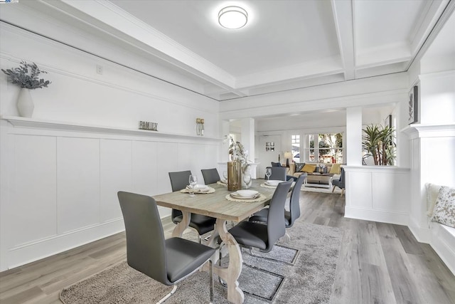 dining area featuring beamed ceiling, wood-type flooring, coffered ceiling, and ornamental molding