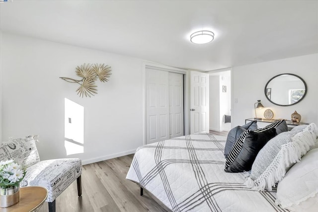 bedroom with light hardwood / wood-style floors and a closet