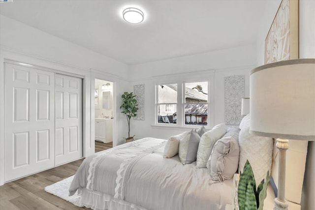 bedroom with hardwood / wood-style flooring, a closet, and ensuite bathroom