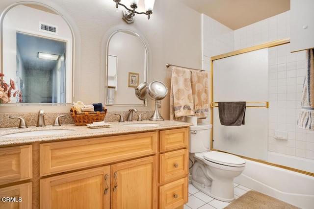 full bathroom featuring vanity, tile patterned floors, shower / bath combination with glass door, and toilet