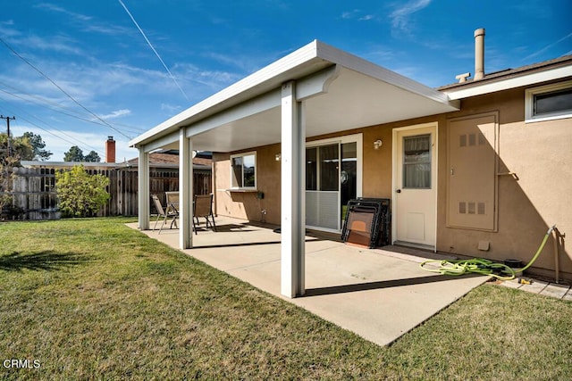 rear view of property featuring a lawn and a patio