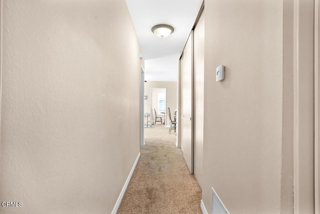 hall featuring light colored carpet