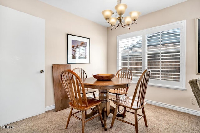 carpeted dining room with an inviting chandelier