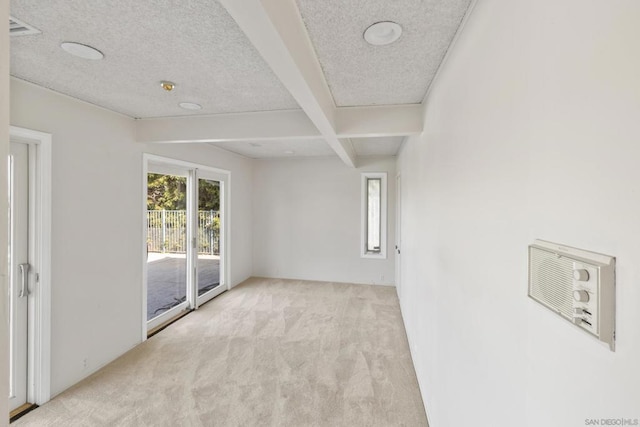 carpeted empty room with coffered ceiling, beam ceiling, and a textured ceiling