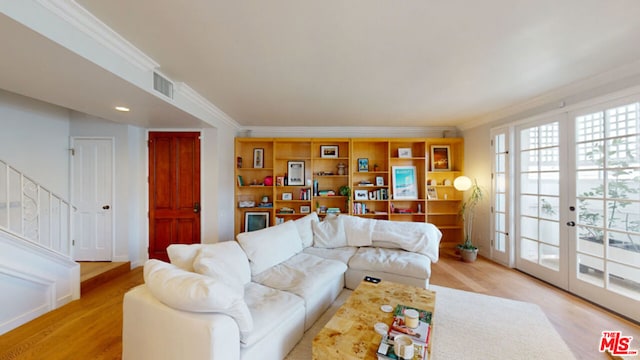 living room featuring ornamental molding, light hardwood / wood-style floors, and french doors