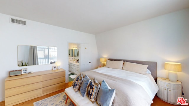 bedroom featuring wood-type flooring and connected bathroom