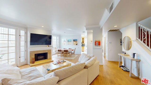 living room featuring crown molding and light hardwood / wood-style flooring