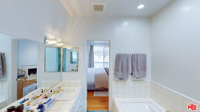 bathroom with wood-type flooring, a bathtub, and vanity