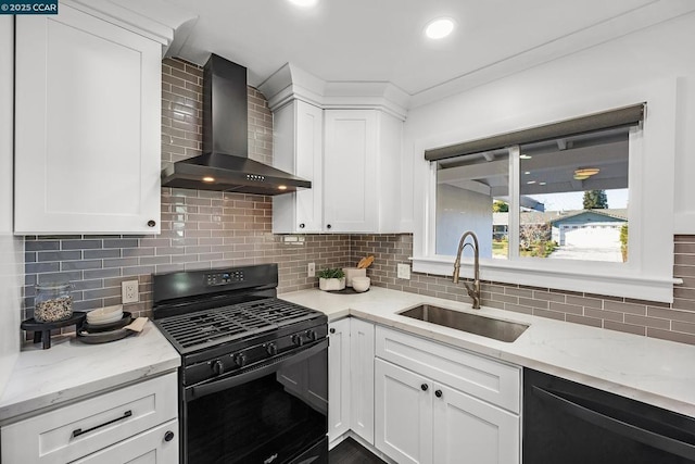 kitchen with tasteful backsplash, sink, white cabinets, black appliances, and wall chimney range hood