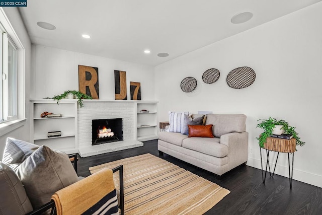 living room with dark wood-type flooring and a fireplace