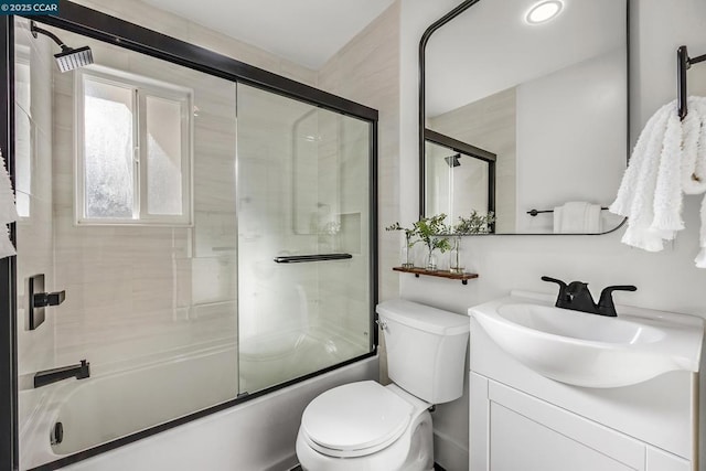 full bathroom with vanity, shower / bath combination with glass door, and toilet