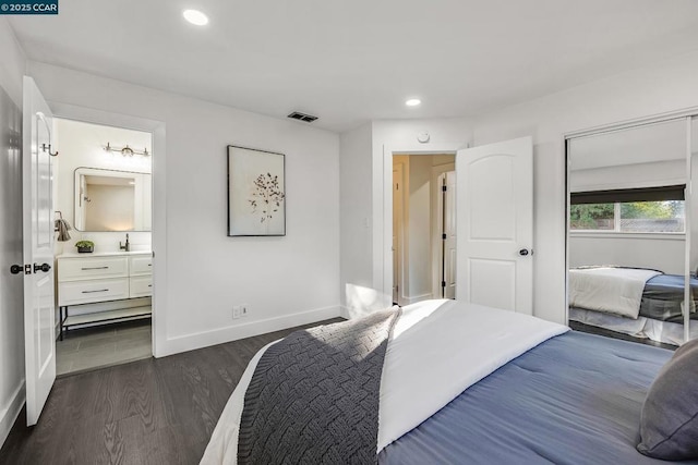 bedroom with dark hardwood / wood-style floors and connected bathroom