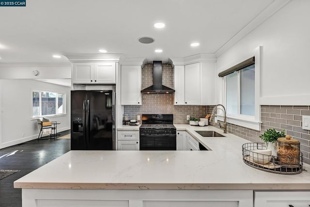 kitchen featuring white cabinetry, sink, wall chimney range hood, and black appliances