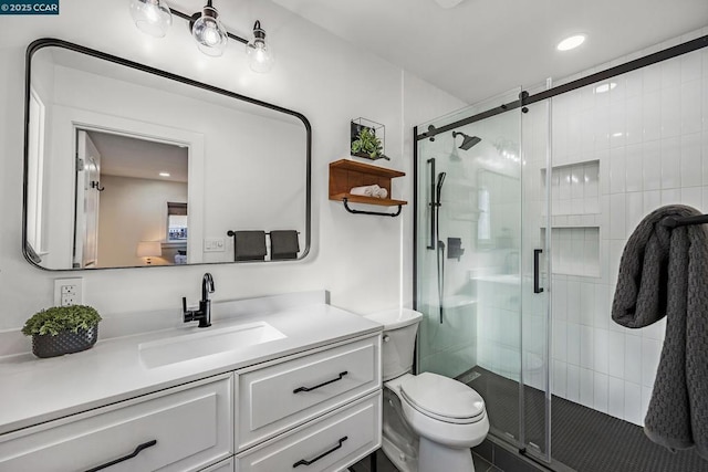 bathroom featuring vanity, toilet, and an enclosed shower