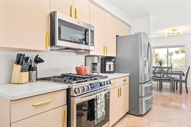 kitchen featuring stainless steel appliances, tasteful backsplash, light tile patterned floors, and cream cabinetry