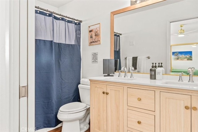 bathroom featuring double vanity, toilet, a shower with shower curtain, and a sink