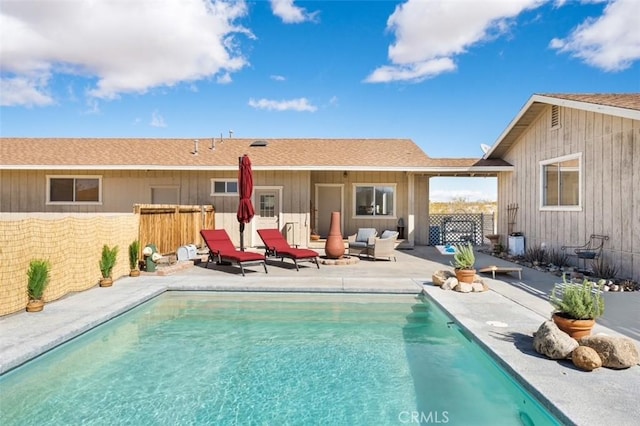 back of property featuring a patio area, a fenced in pool, and fence