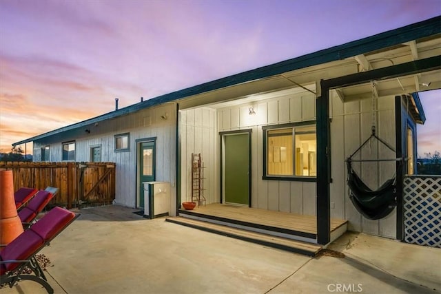 back house at dusk with a patio area