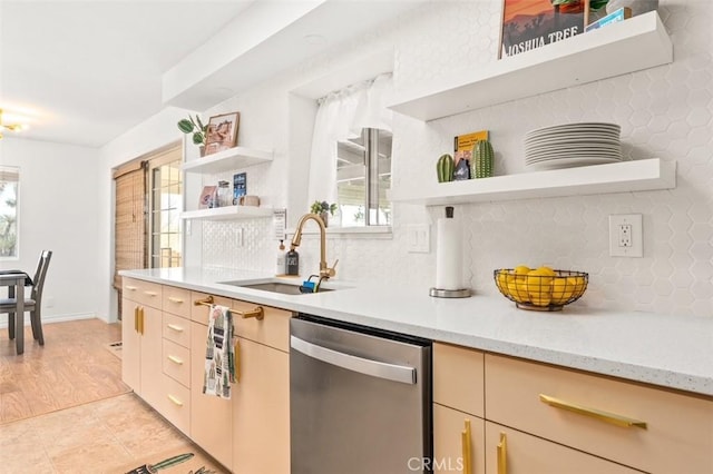 kitchen featuring open shelves, backsplash, stainless steel dishwasher, and a sink