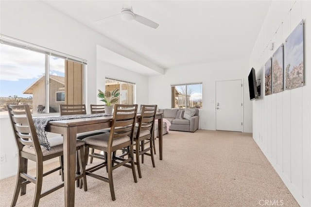 dining area with plenty of natural light, a ceiling fan, and light carpet