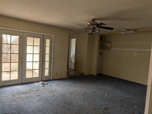 spare room featuring french doors, carpet flooring, and a textured ceiling