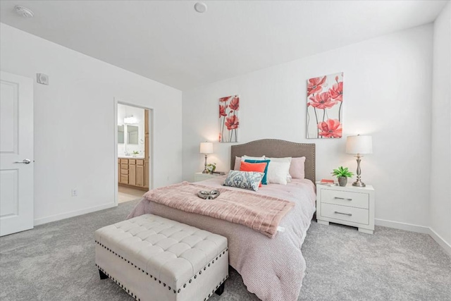 bedroom featuring ensuite bathroom and light carpet