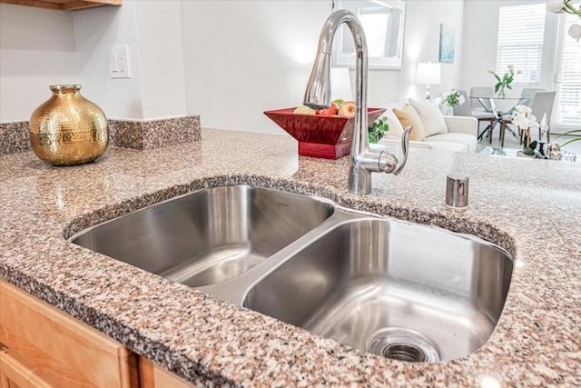 room details featuring light stone counters and sink