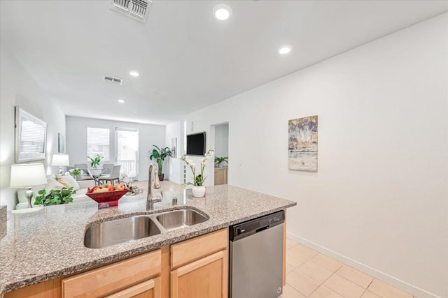 kitchen featuring light brown cabinetry, sink, light stone counters, light tile patterned floors, and stainless steel dishwasher