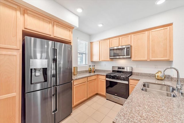 kitchen featuring light tile patterned flooring, appliances with stainless steel finishes, sink, and light brown cabinetry