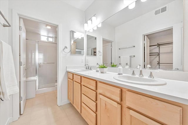 bathroom featuring vanity, tile patterned flooring, a shower with shower door, and toilet